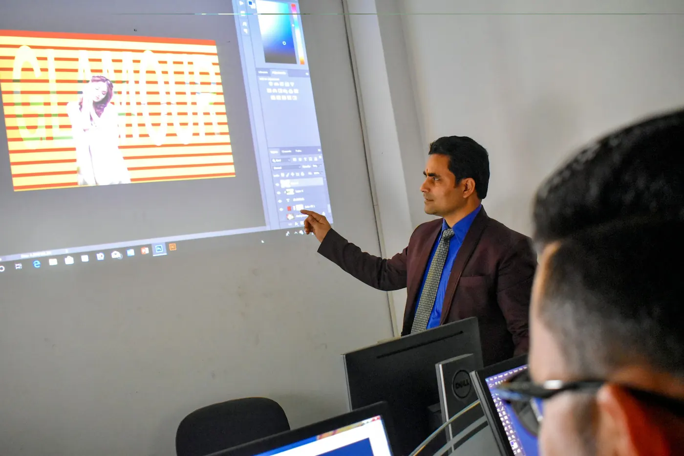A D-TECH trainer explaining a design project on the projector screen to a class